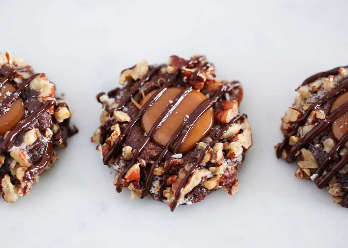 Turtle cookies have everything you want in a decadent holiday cookie. They're crunchy, nutty, chocolaty, sweet and salty, soft and chewy, and completely addicting! turtle cookies on counter