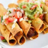 beef taquitos with guacamole and pico on top