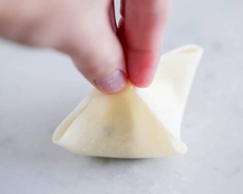 pinching wonton wrappers together