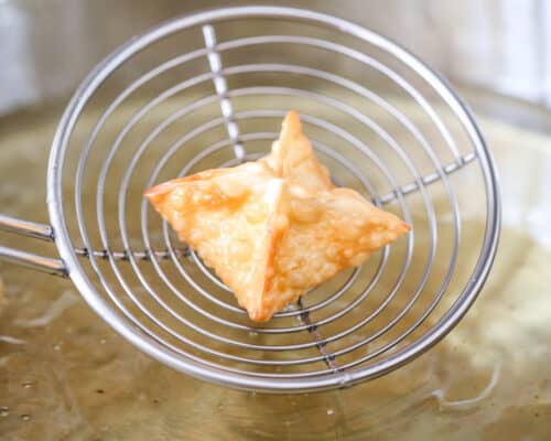 removing wonton from oil with spoon