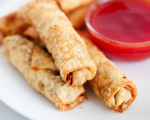 stacked egg rolls with sweet and sour sauce in bowl