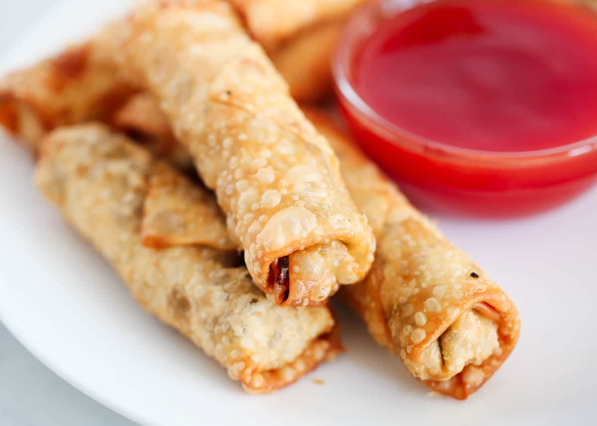 stacked egg rolls with sweet and sour sauce in bowl