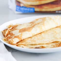crepes on white plate with pancake mix in background