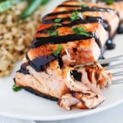 fork taking bite of salmon on plate