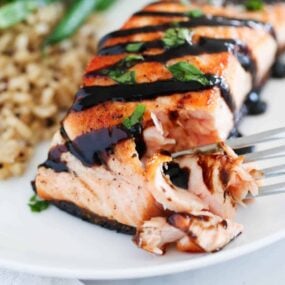 fork taking bite of salmon on plate