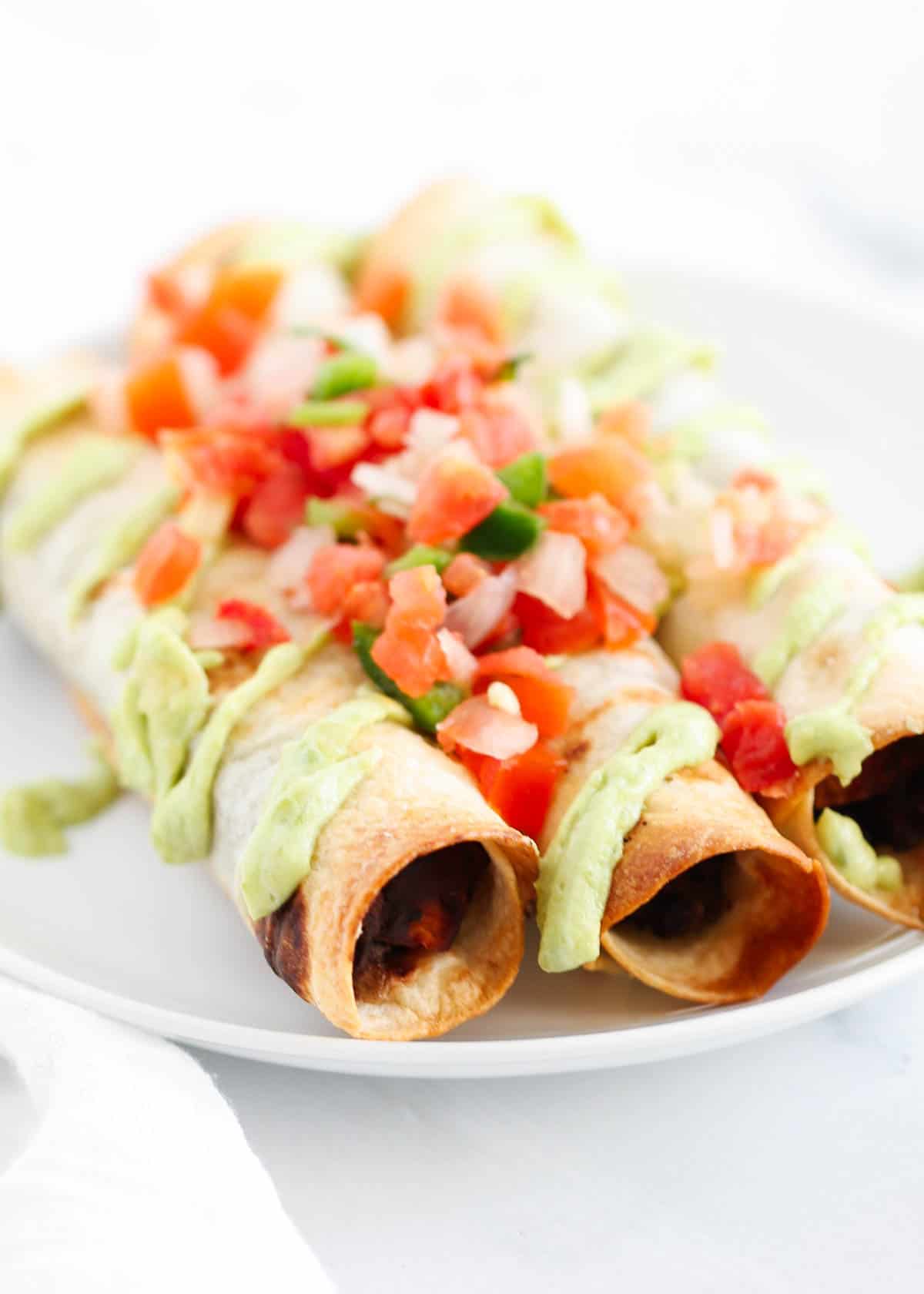 black bean taquitos on white plate