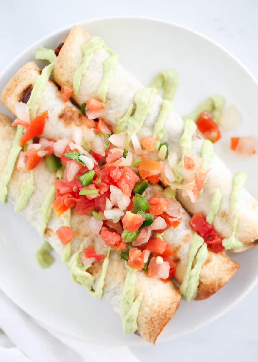 taquitos with pico on white plate