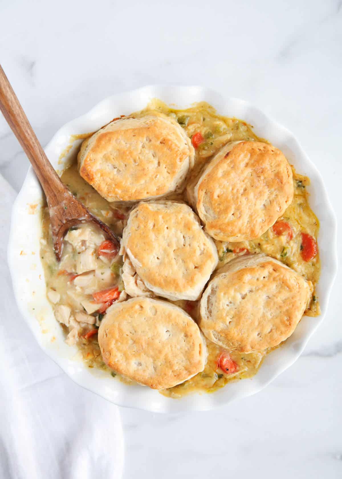 spoon of biscuits on top of chicken pot pie