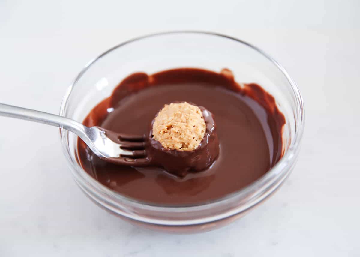 dipping rice krispie ball in chocolate
