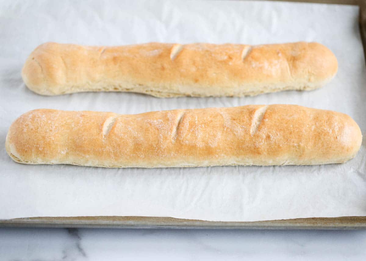 french baguettes on baking sheet with parchment paper