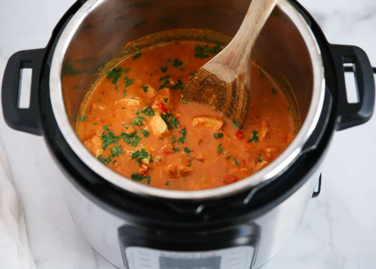 Butter chicken in the instant pot with spoon.