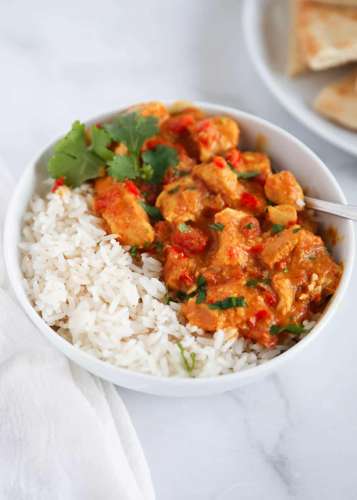 Butter chicken and rice in bowl.