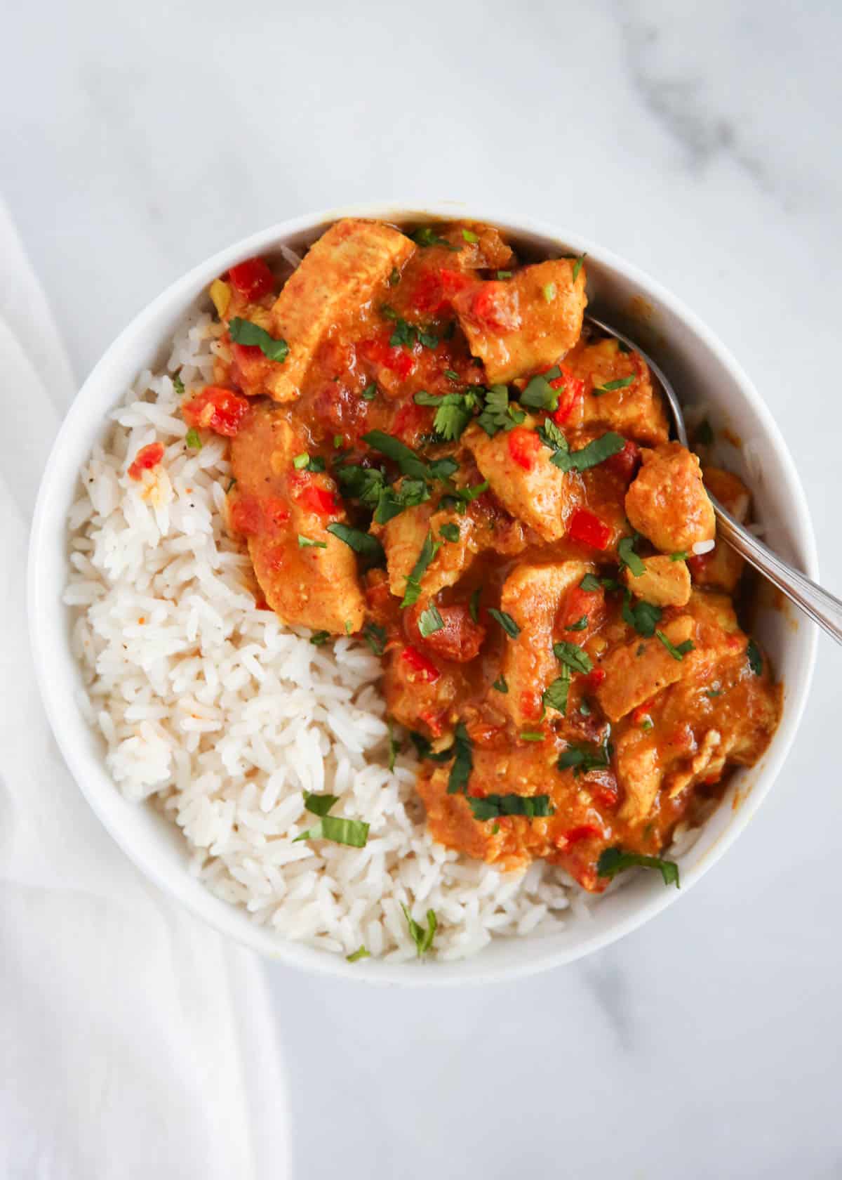 Butter chicken and rice in bowl.
