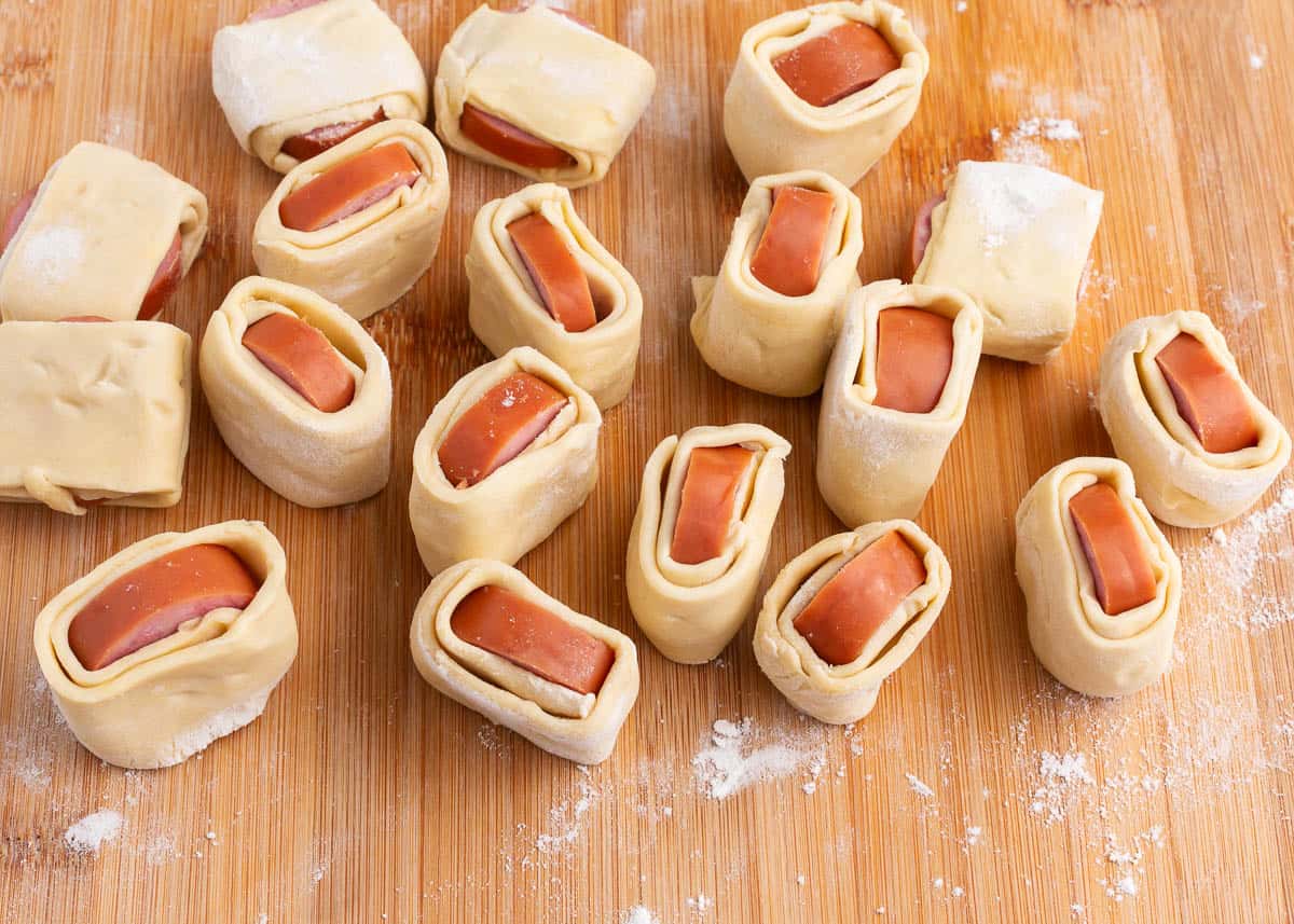 rolled up sausages on cutting board