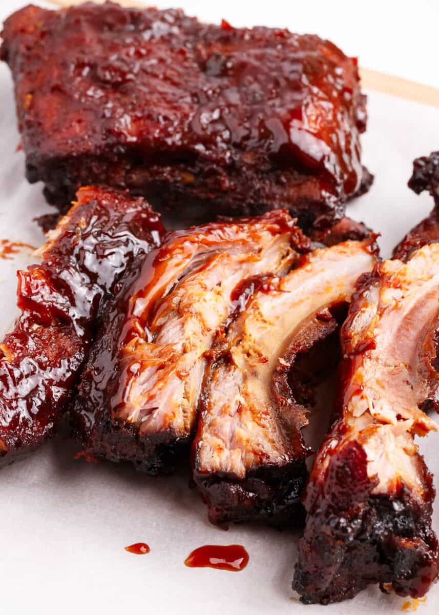 Slow Cooker Ribs - Easy baby back ribs smothered with a homemade rub and sweet and tangy barbecue sauce. Cooked to perfection in the crockpot and fall off the bone delicious. These are the best slow cooker ribs! ribs with sauce on top