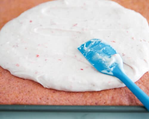 spreading frosting on strawberry cake