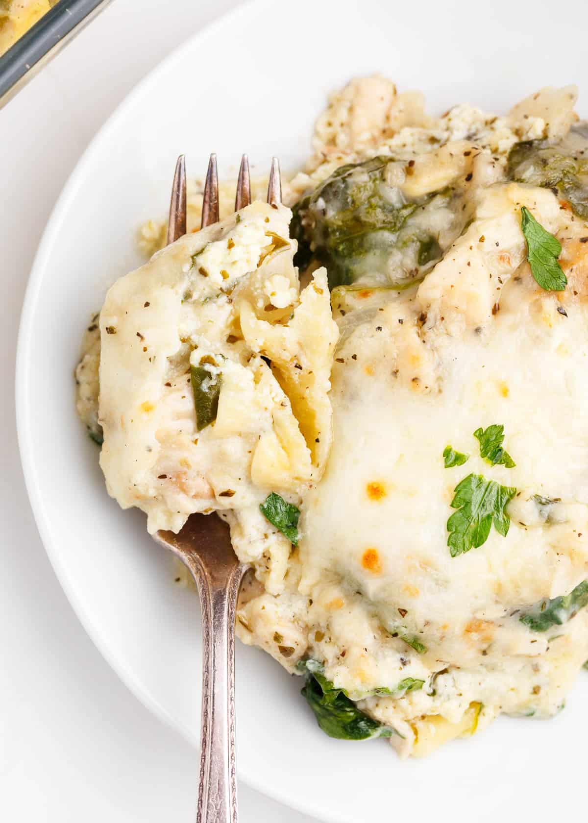 fork with white chicken lasagna on plate