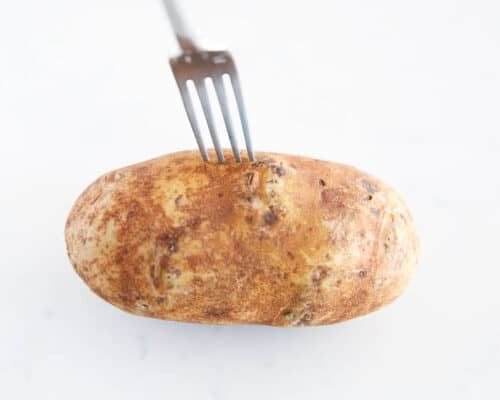 Poking a potato with a fork.