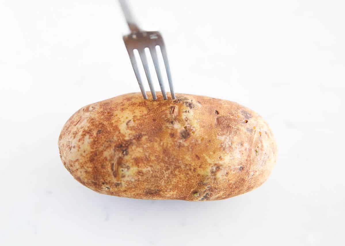 Poking a potato with a fork.