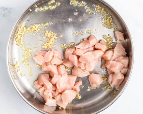 cooking chicken and garlic in skillet