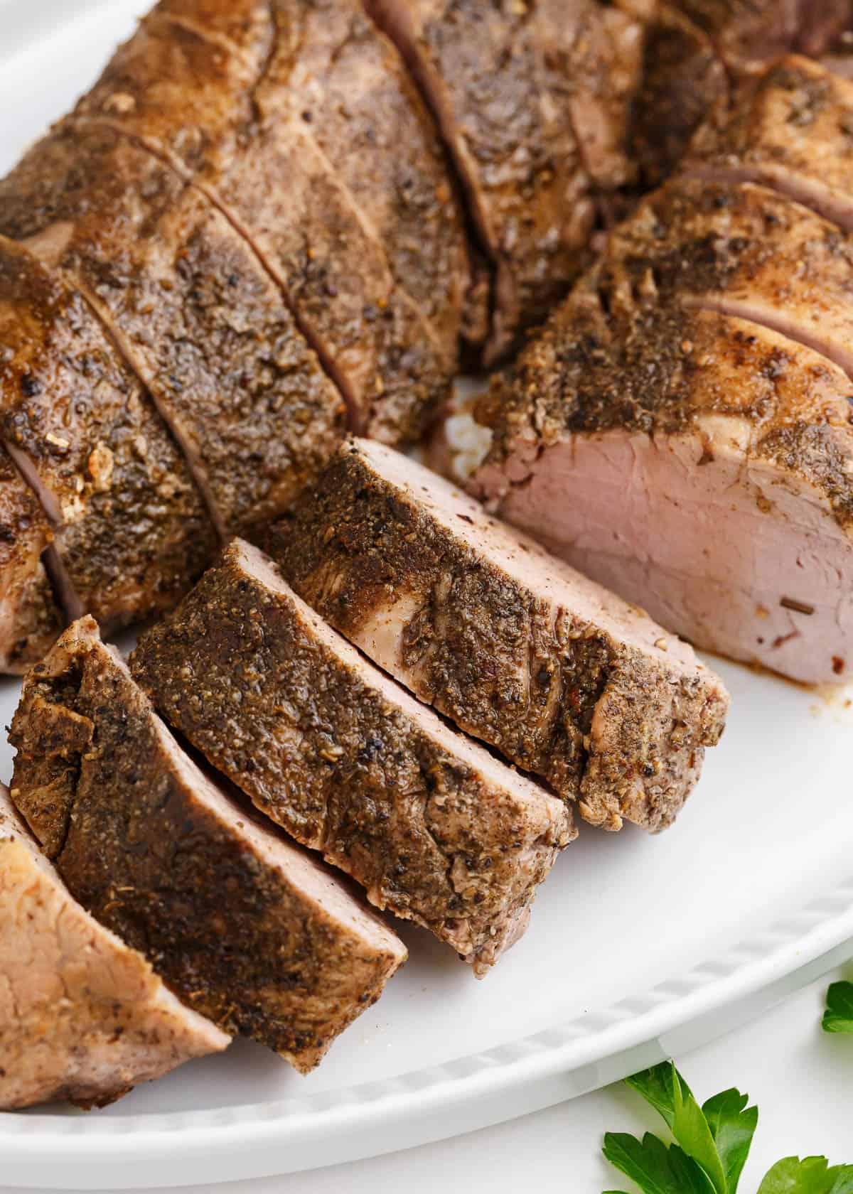 sliced pork tenderloin on white plate