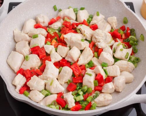 cooking chicken and bell peppers in skillet
