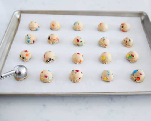 mini m&m cookie dough balls on baking sheet