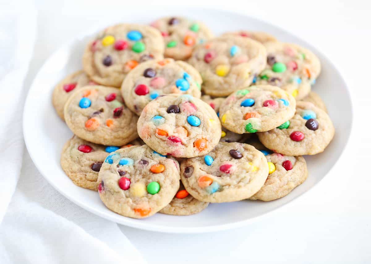 Mini m&m cookies on white plate.