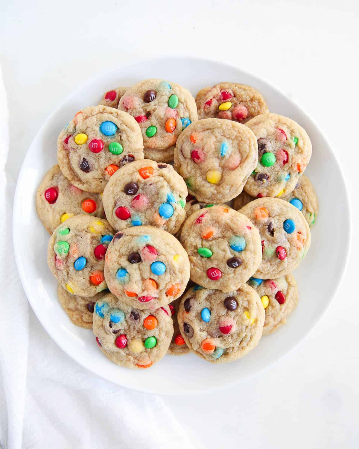 Mini m&m cookies on white plate.