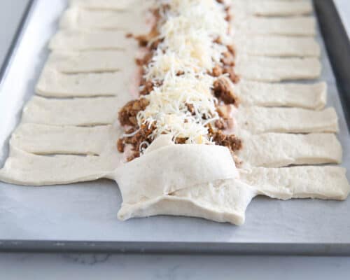 wrapping dough around taco meat