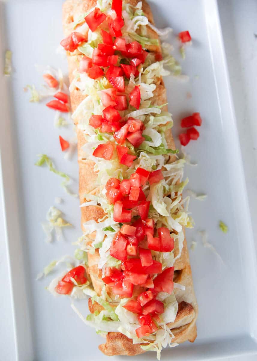 taco braid on white plate with tomatoes