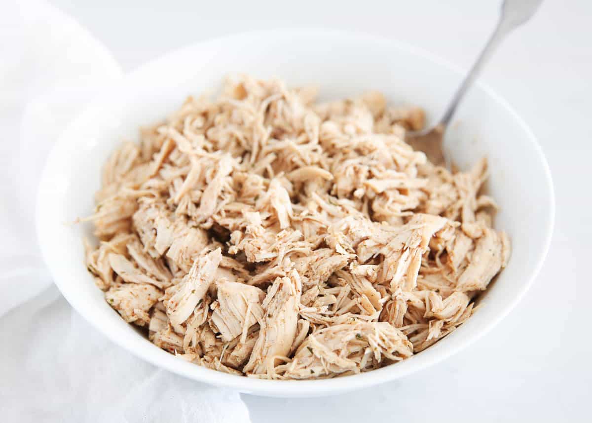 Shredded chicken in a white bowl.