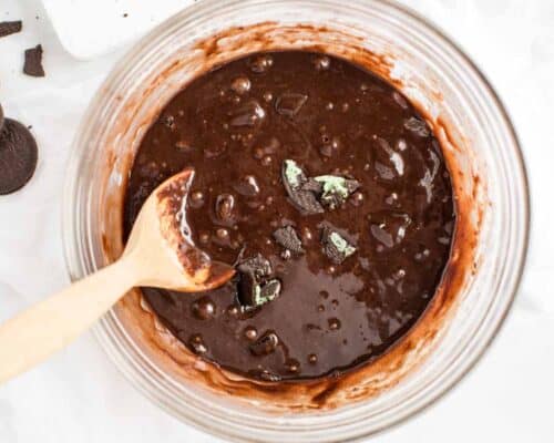 mixing brownie batter in glass bowl