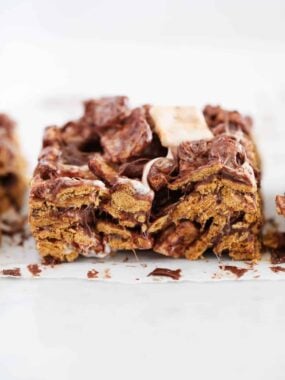 Close-up of a Golden Graham s&rsquo;mores bar with visible cereal, marshmallow, and chocolate chunks.