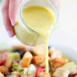 pouring dressing on top of salad