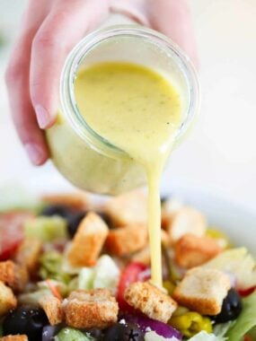pouring dressing on top of salad
