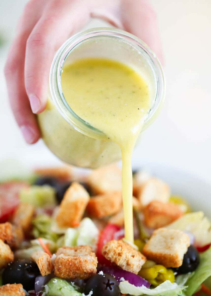 pouring dressing on top of salad