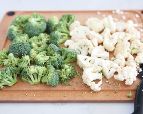 cutting cauliflower and broccoli on cutting board