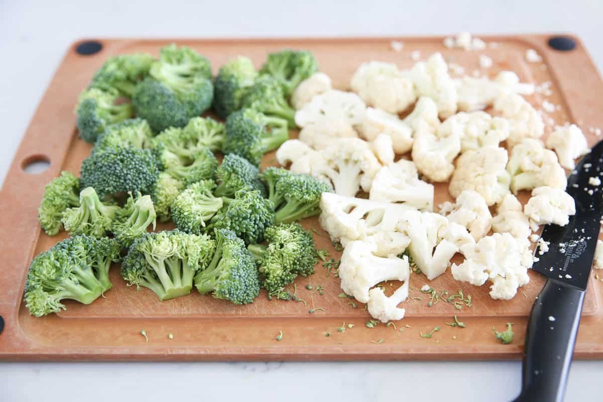 cutting cauliflower and broccoli on cutting board