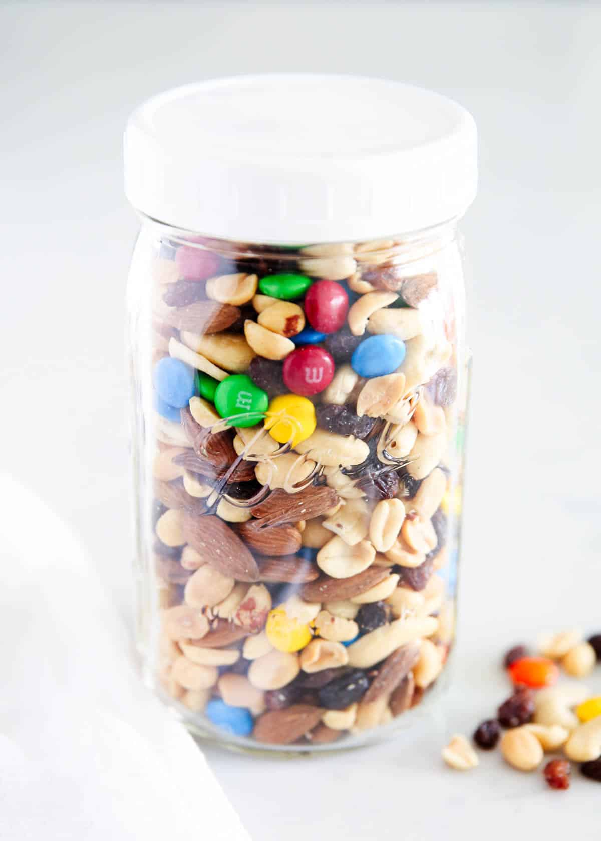 Trail mix in glass jar with a white lid.