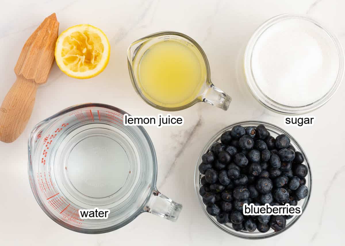 Blueberry lemonade ingredients on marble counter.