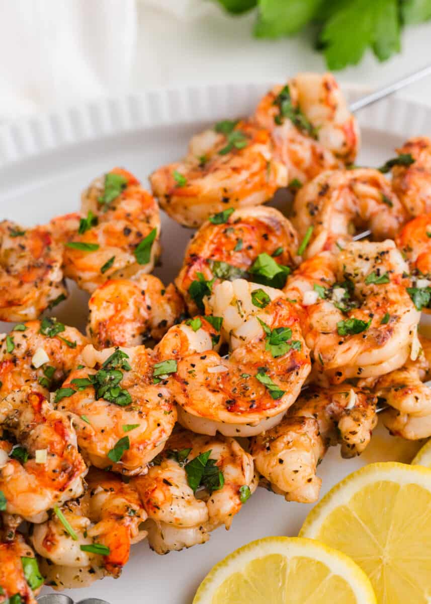 Grilled shrimp skewers on a white plate.