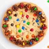 M&M cookie cake on white plate.