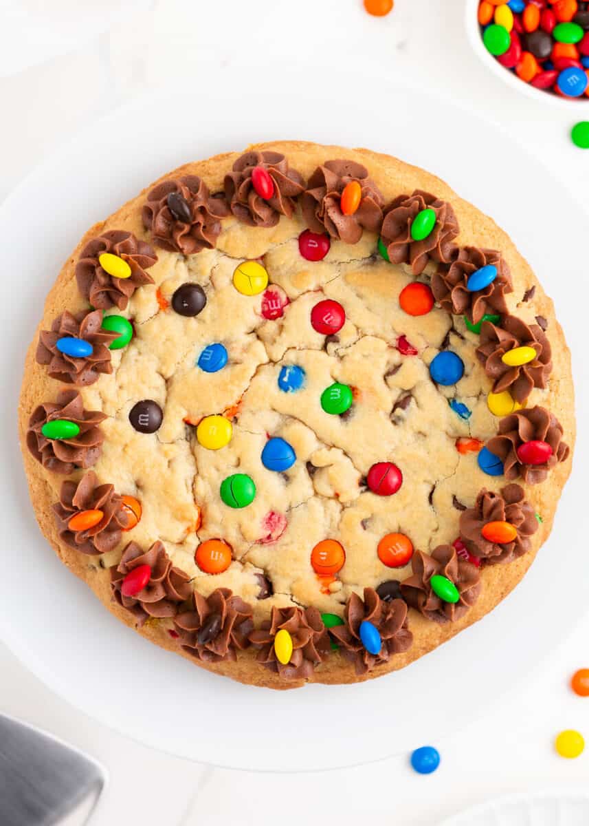 M&M cookie cake on white plate.