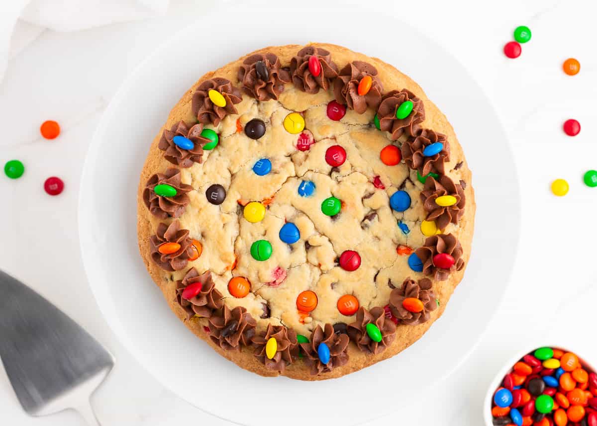 M&M cookie cake on white plate.