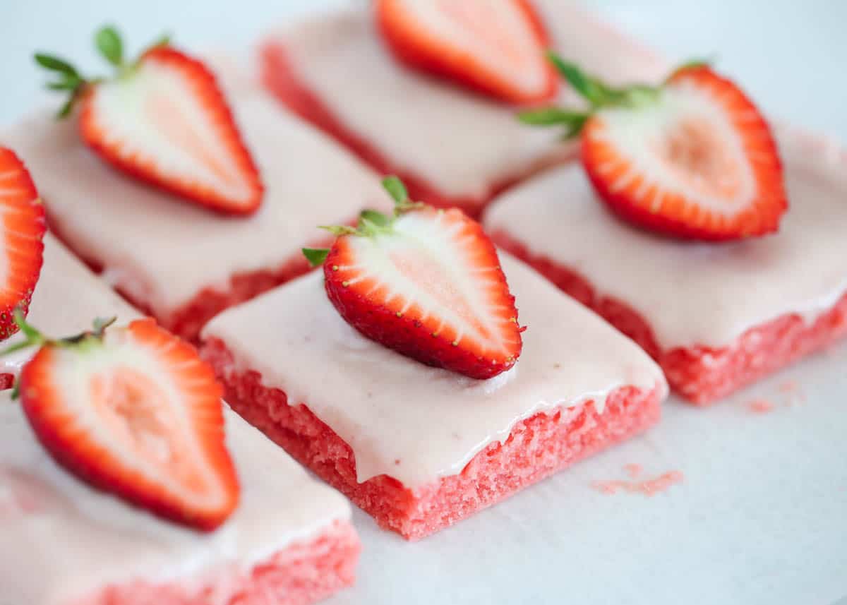 These strawberry brownies are moist, decadent and easy to make with a strawberry cake mix! For even more strawberry flavor, top them with a homemade glaze made from strawberry jam. Sliced strawberry brownies.