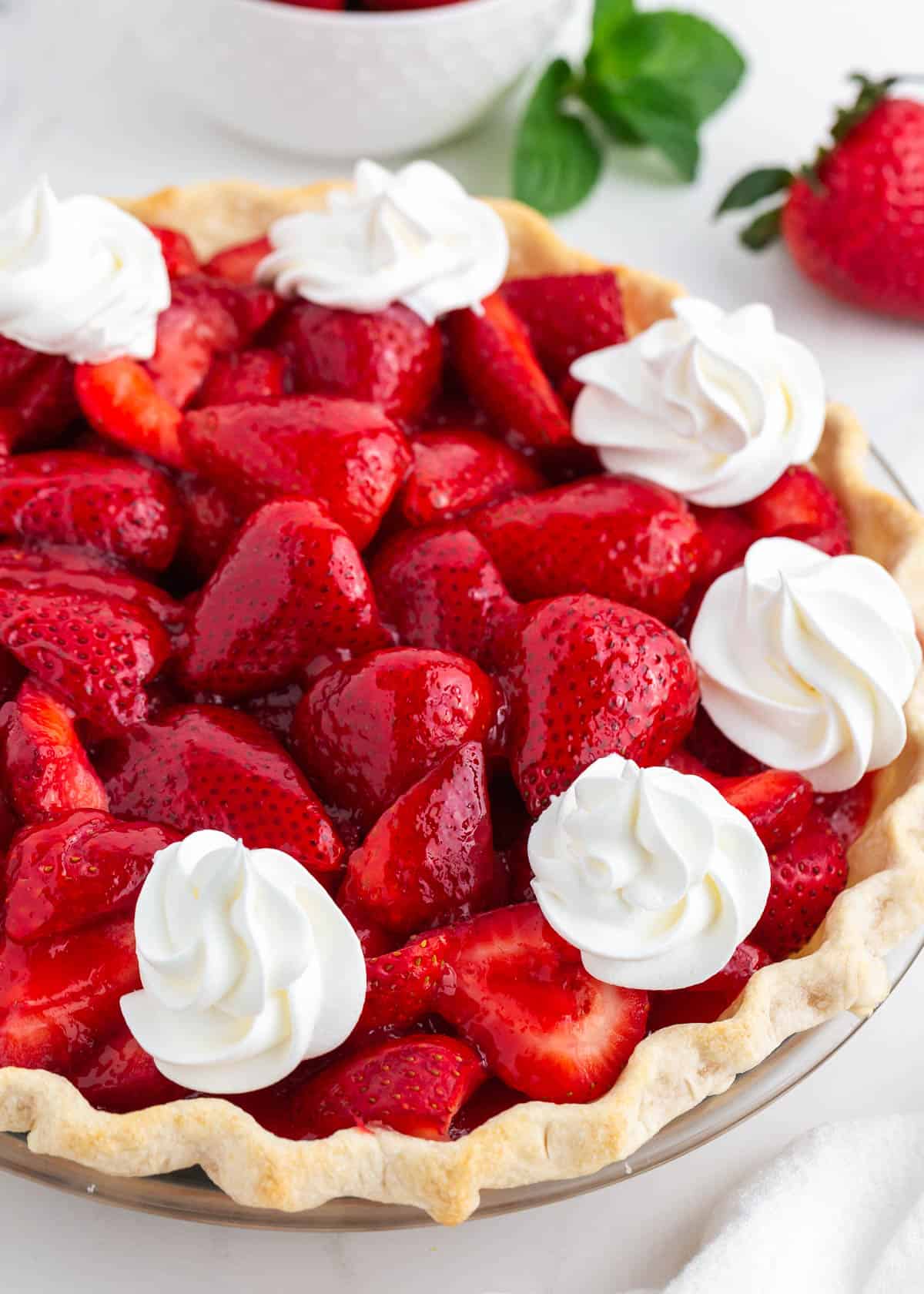 Close up of fresh strawberry pie on a marble countertop.