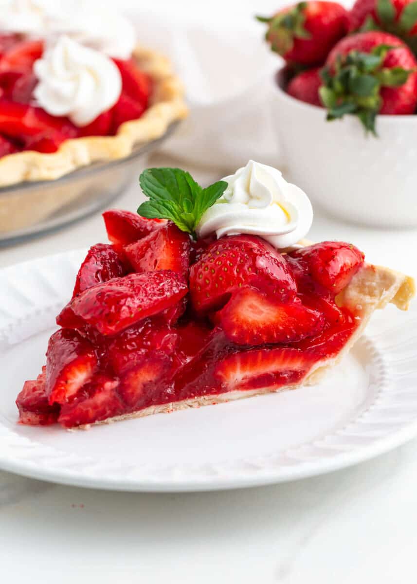 Slice of fresh strawberry pie on a white plate.
