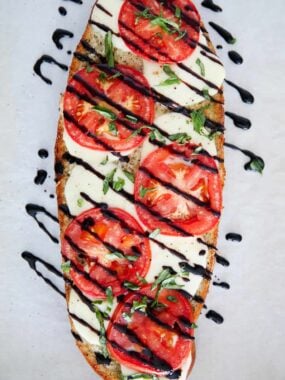 Caprese bread drizzled with balsamic glaze.