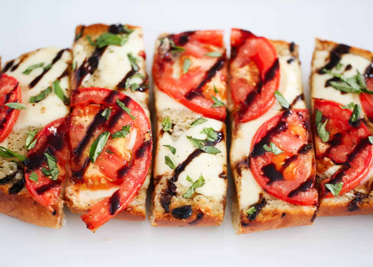 Sliced caprese bread drizzled with balsamic glaze.